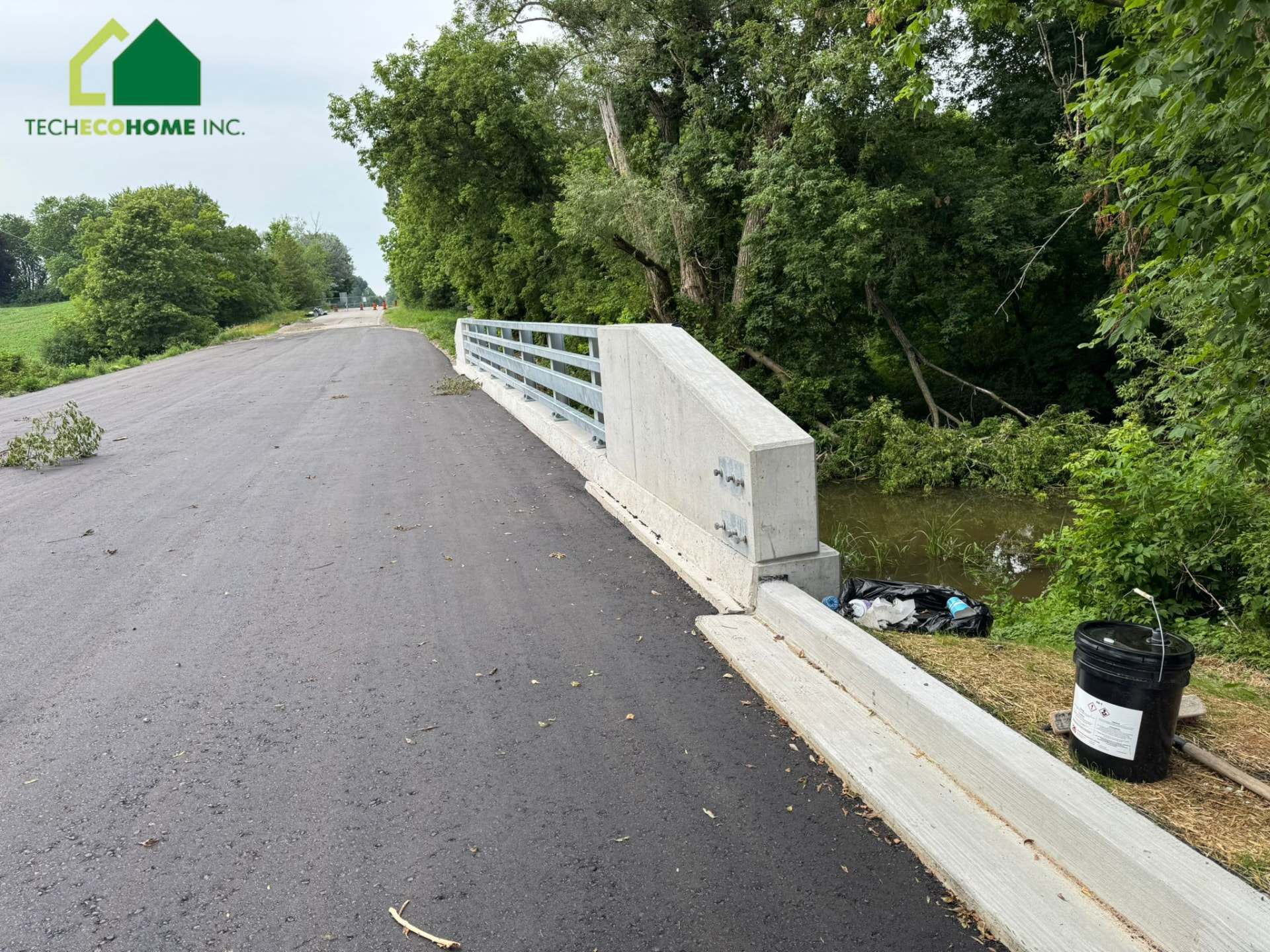 Cast-in-place concrete bridge barrier wall and approach curb with the TECHECOHOME INC. logo