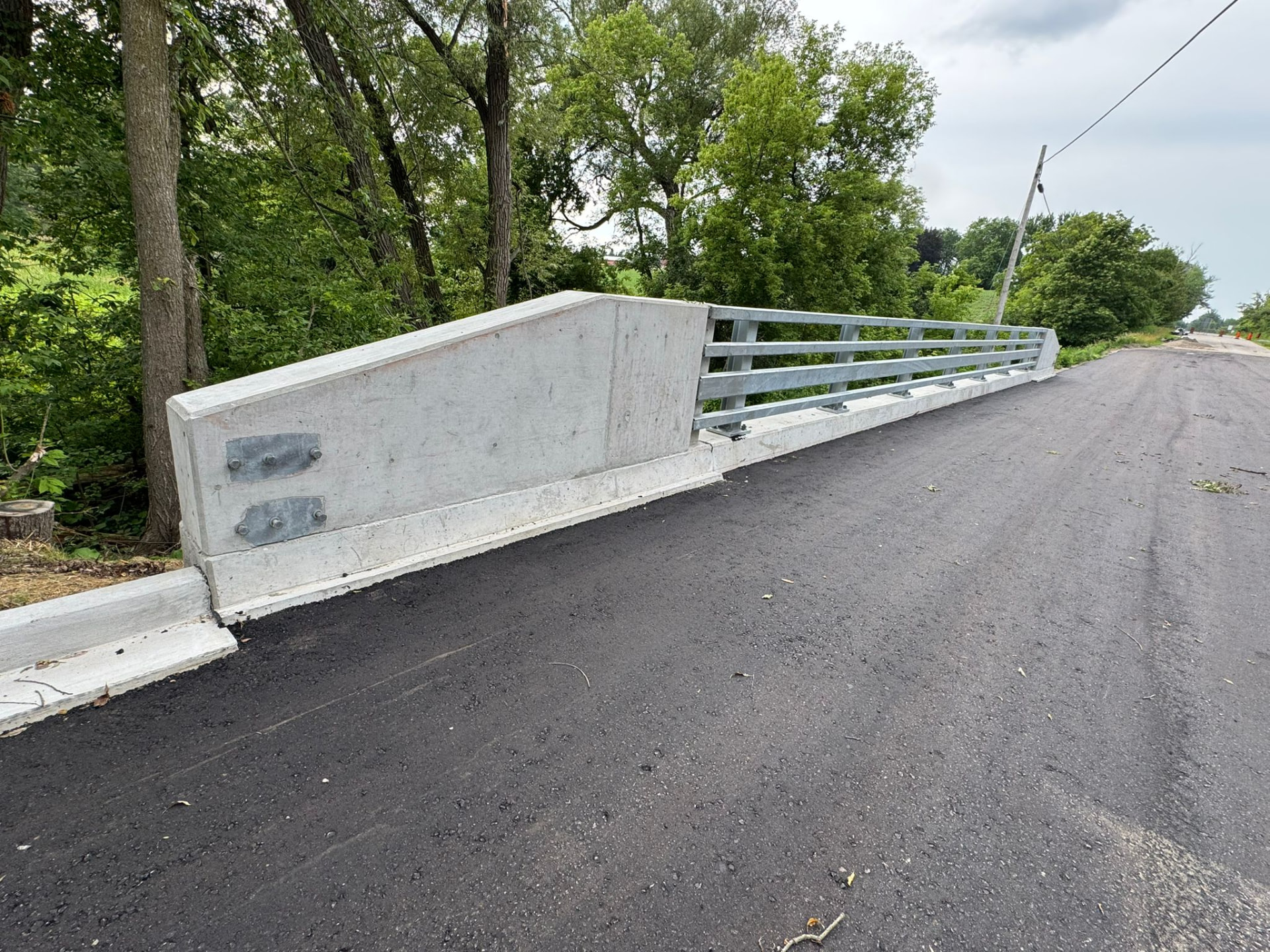 Cast-in-place concrete end block with bolted railing connection plates
