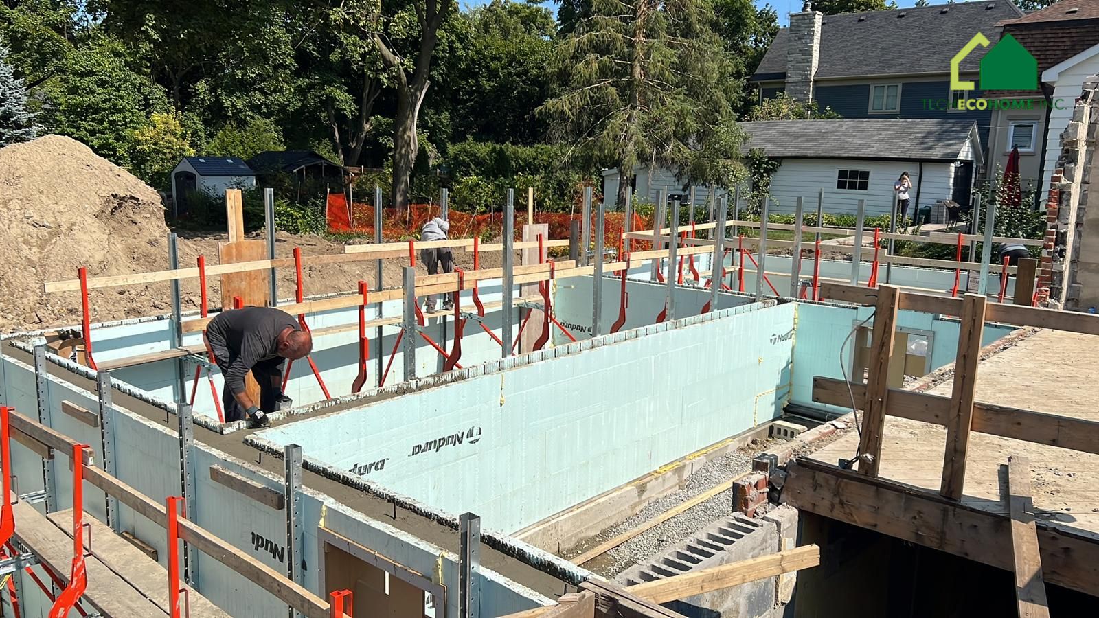 Crew placing concrete into braced ICF basement walls