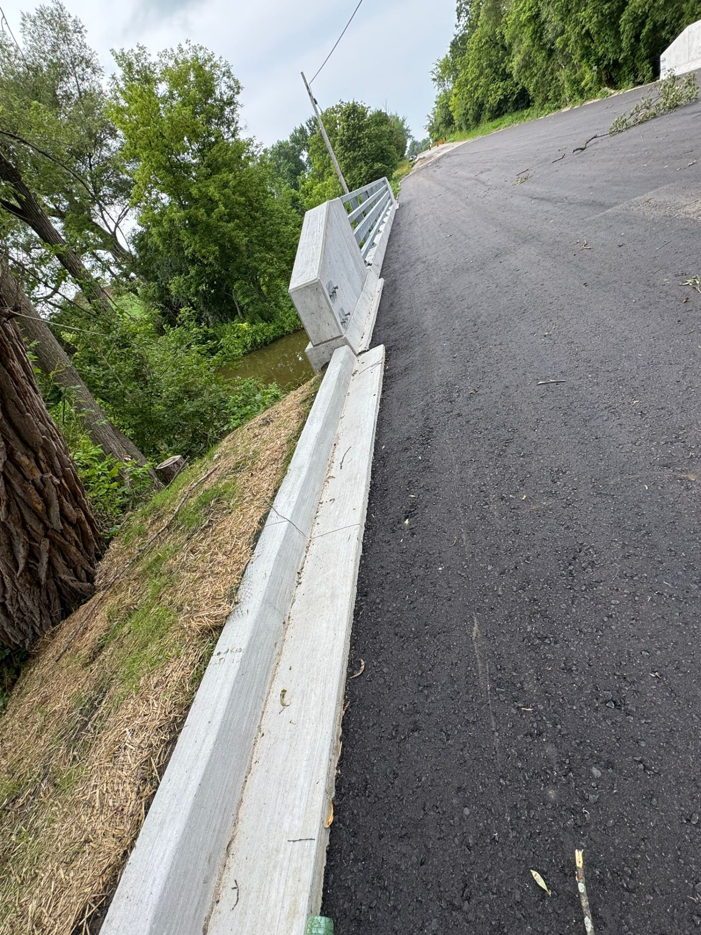 Concrete curb and barrier wall along the bridge approach slope