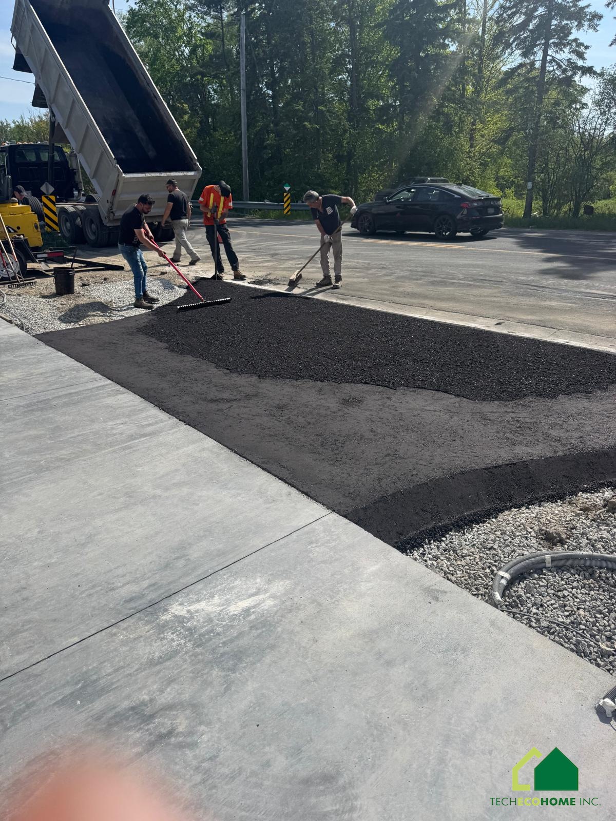 Asphalt paving alongside a finished concrete apron